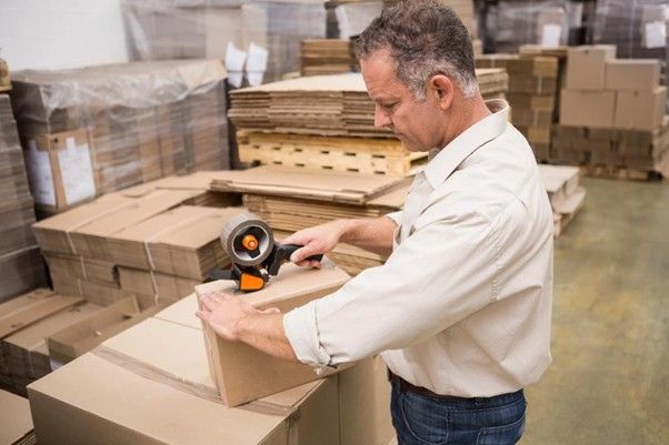 mężczyzna składający karton